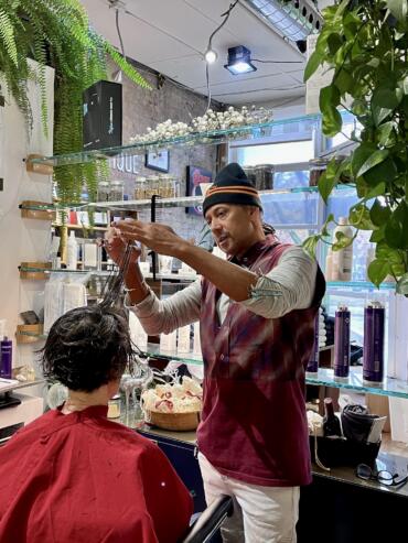 A hairstylist demonstrating a hair styling technique to a customer in a modern salon.