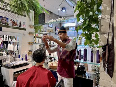 A hairstylist demonstrating a hair styling technique to a customer in a modern salon.