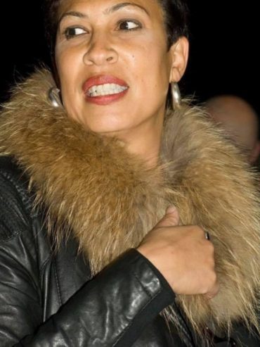 Close-up of Sharmain in a black leather jacket with a fur collar, showcasing a bold fashion statement.