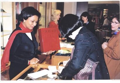 Women browsing at a bookstore event, with one woman holding a red 'Bollock' book.