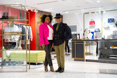 Stylish shoppers smiling inside a boutique with designer accessories and footwear.