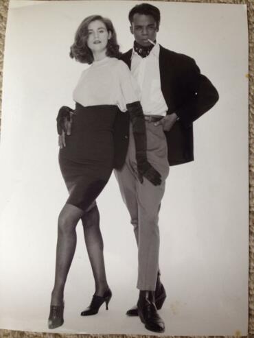 Black-and-white photo of a stylish woman and man posing confidently in vintage fashion.