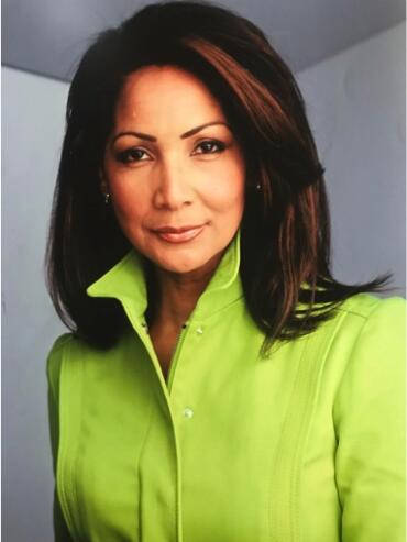 Woman with dark hair in a lime green jacket, posing indoors.