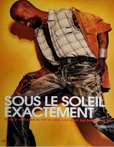 Fashion magazine style: Edgy male model in layered casual attire poses against yellow background.