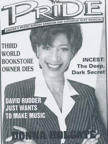 Black and white magazine cover featuring a smiling woman in a pinstripe suit.