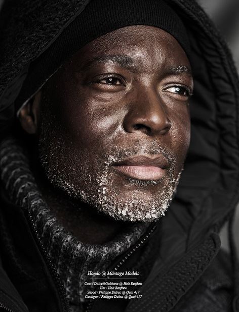 Close-up of a mature man in cold-weather gear with frost on his beard and a pensive expression.