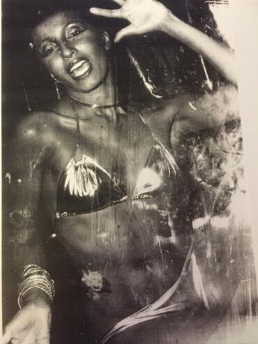Black and white portrait of a woman in vibrant attire, smiling with an expressive pose.