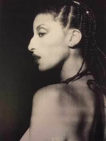 Black and white portrait of a woman with braided hair, turning slightly to the side.