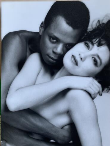 Black and white portrait of two women embracing, showcasing expressive faces and natural beauty.
