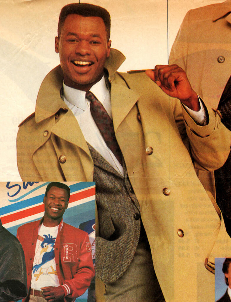 Man smiling in a beige trench coat and patterned tie.