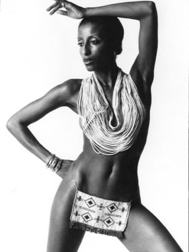 Elegant necklace and patterned hip bag paired with striking black-and-white portrait.