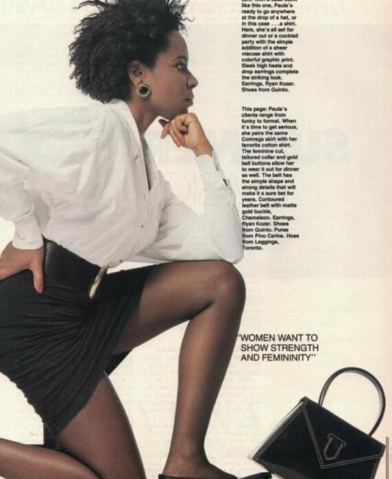 Side profile of a woman wearing a white shirt, black skirt, and black heels, with large earrings and a black handbag.