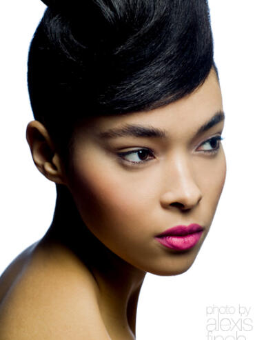 Close-up of a woman with sleek black hairstyle and bright pink lipstick.