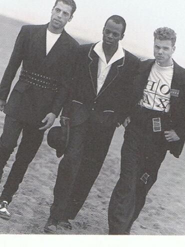 Three men walking in stylish outfits, with "Hoax Couture" text at the bottom.