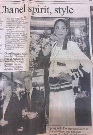 Woman in elegant white and navy Chanel outfit at a fashion event.