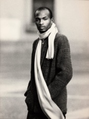 Stylish man in a coat with a scarf, black-and-white portrait.