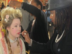 Young girl with pastel hairstyle and vintage makeup, getting ready backstage.