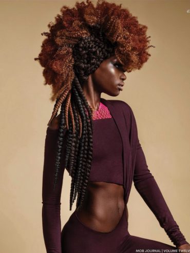 Profile of a person with styled brown and black twisted hair wearing a maroon outfit.