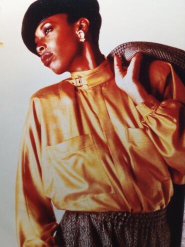 Elegant woman in vintage style, wearing a gold satin blouse and statement earrings.