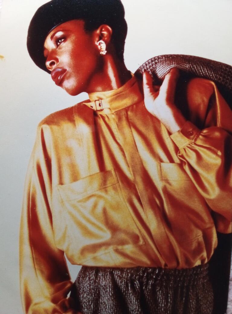 Elegant woman in vintage style, wearing a gold satin blouse and statement earrings.