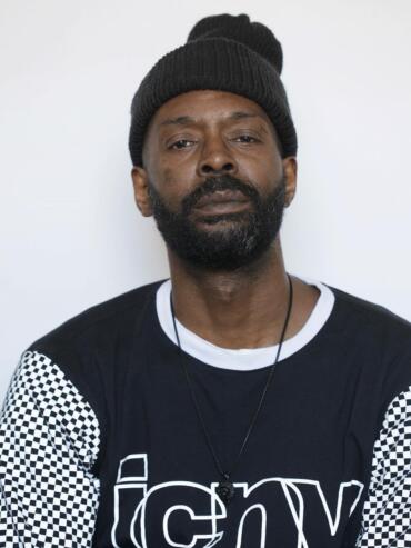 Male model with a beanie, black and white graphic sweatshirt, and a necklace.
