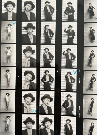 Black and white photos of a woman in vintage-inspired outfits and accessories, including a wide-brimmed hat and blazer, posing with different expressions and gestures.