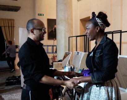 Two women share a handshake and friendly conversation at a networking event.