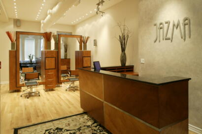 Elegant reception area with wooden furnishings and decorative vases in a fashion studio.