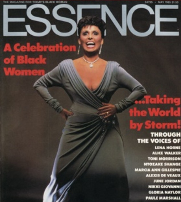 Fashion magazine cover featuring a woman in an elegant gray gown with bold jewelry.