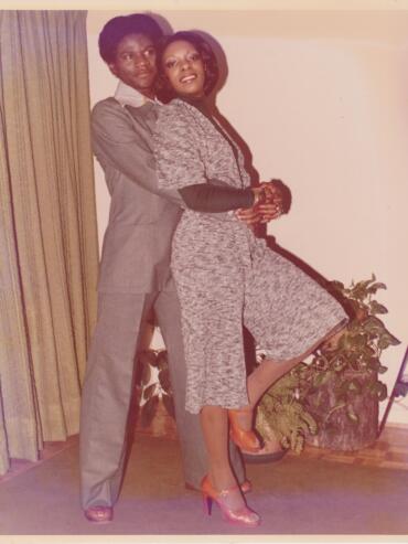 Vintage photo of two women posing indoors, dressed in stylish 1980s fashion.