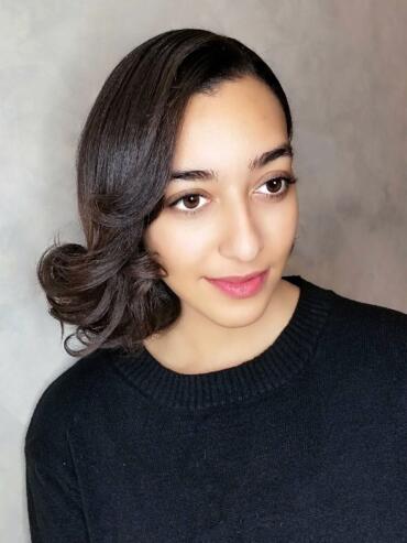 Portrait of a woman with smooth, styled hair wearing a black top, showcasing elegant simplicity.