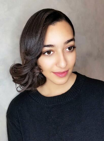 Portrait of a woman with smooth, styled hair wearing a black top, showcasing elegant simplicity.