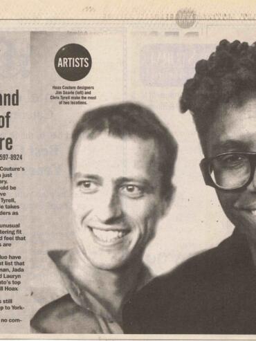 Black-and-white photo of two fashion designers, Jim Searle and Chris Tyrell, smiling.