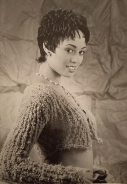 Elegant woman with a textured sweater and short hairstyle, adorned with a pearl necklace.