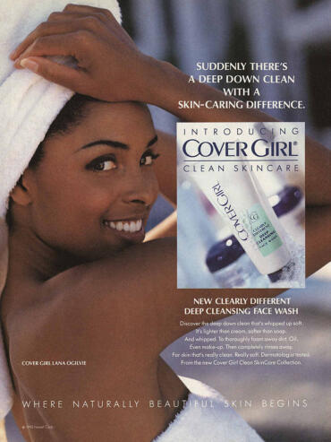 Woman smiling with skincare product, promoting CoverGirl Clean Skincare face wash.