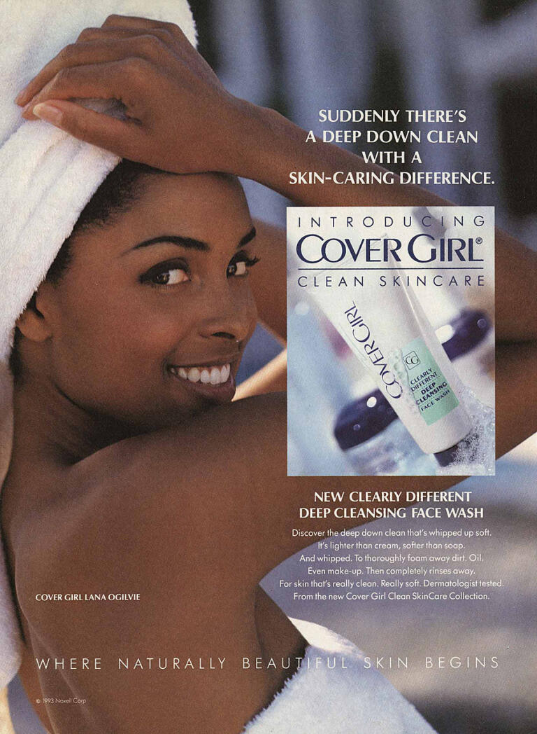 Woman smiling with skincare product, promoting CoverGirl Clean Skincare face wash.
