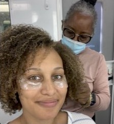 Woman receiving a facial treatment from a professional in a clinic setting.