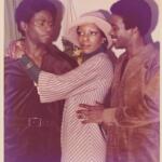 Three stylish individuals sharing an intimate moment, dressed in vintage fashion.