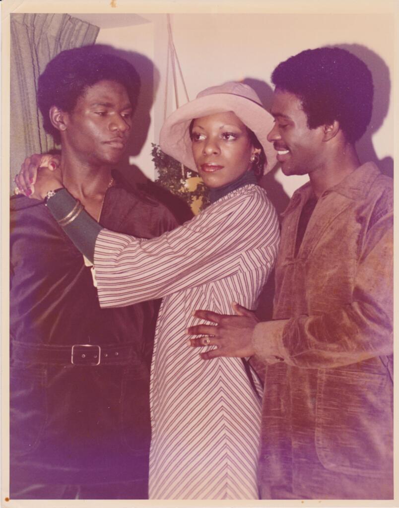 Three stylish individuals sharing an intimate moment, dressed in vintage fashion.