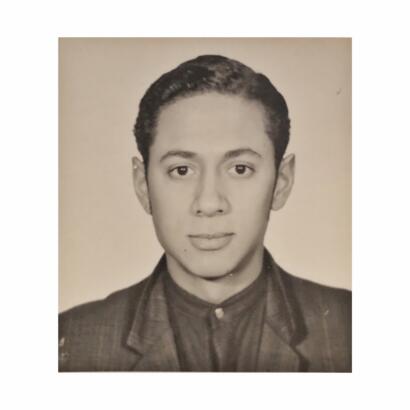 Black and white portrait of a young man in formal attire with slicked back hair.