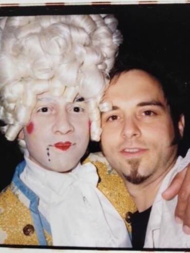 Person dressed as Marie Antoinette with elaborate wig and makeup, posing with a man.
