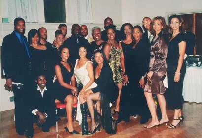 Group of professionally dressed individuals at an indoor event, posing for a photo.