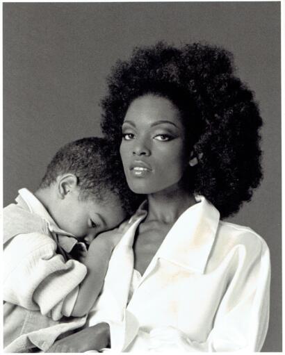 Black-and-white portrait of a woman with natural hair and a child resting on her shoulder.
