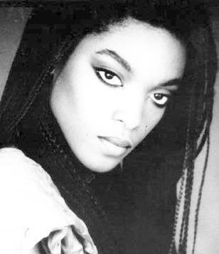Black and white portrait of a woman with intense gaze and fashionable braided hairstyle.