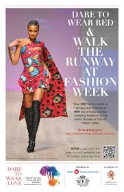 Model walking runway in a vibrant red and pink floral dress with black thigh-high boots.