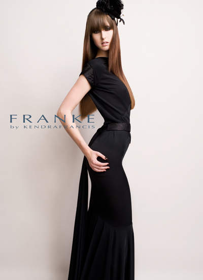Model in an elegant black gown and oversized hat, showcasing fashion designer Franke by Kendra Francis.