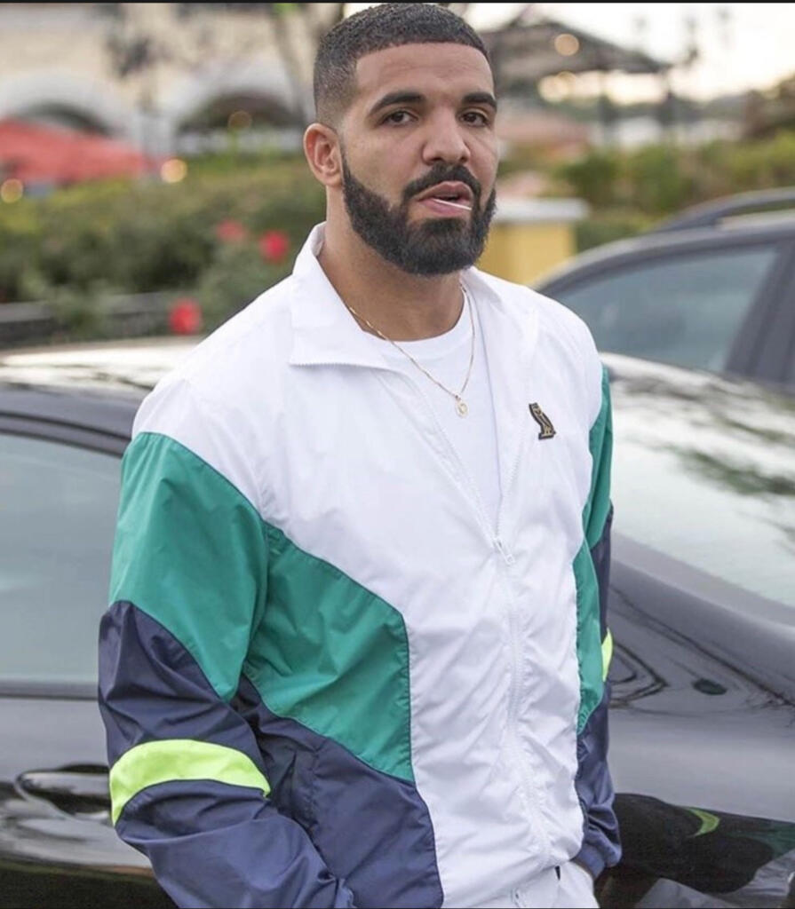 Man wearing a color-blocked windbreaker jacket outdoors.