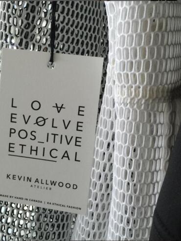 Clothing tag on a perforated fabric, emphasizing love, ethical fashion, and positive values.