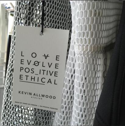 Clothing tag on a perforated fabric, emphasizing love, ethical fashion, and positive values.