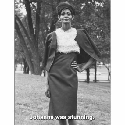 Black and white photo of a woman in elegant fashion, with her hand on her hip, outdoors.
